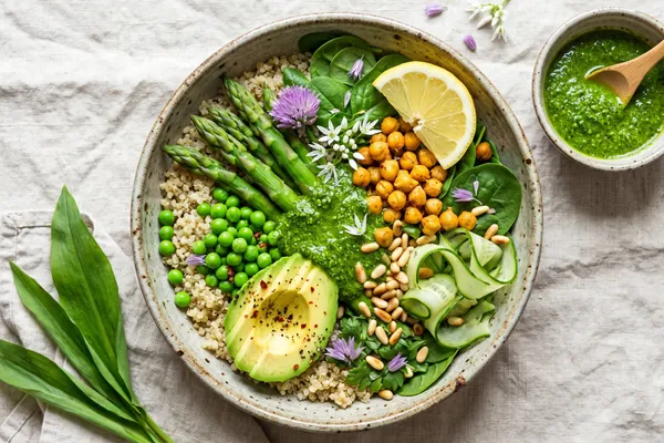 Grüne Frühlings-Bowl mit Quinoa, grünem Spargel, Avocado, Kichererbsen und Bärlauch-Pesto