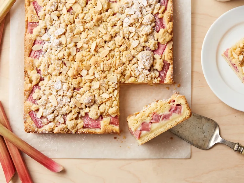 Veganer Rhabarberkuchen vom Blech mit goldbraunen Streuseln und rosa Rhabarberstücken