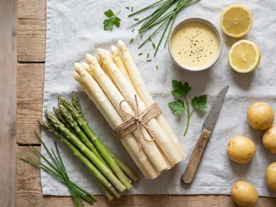 Flatlay mit weißem und grünem Spargel, veganer Hollandaise, Zitrone und Kartoffeln